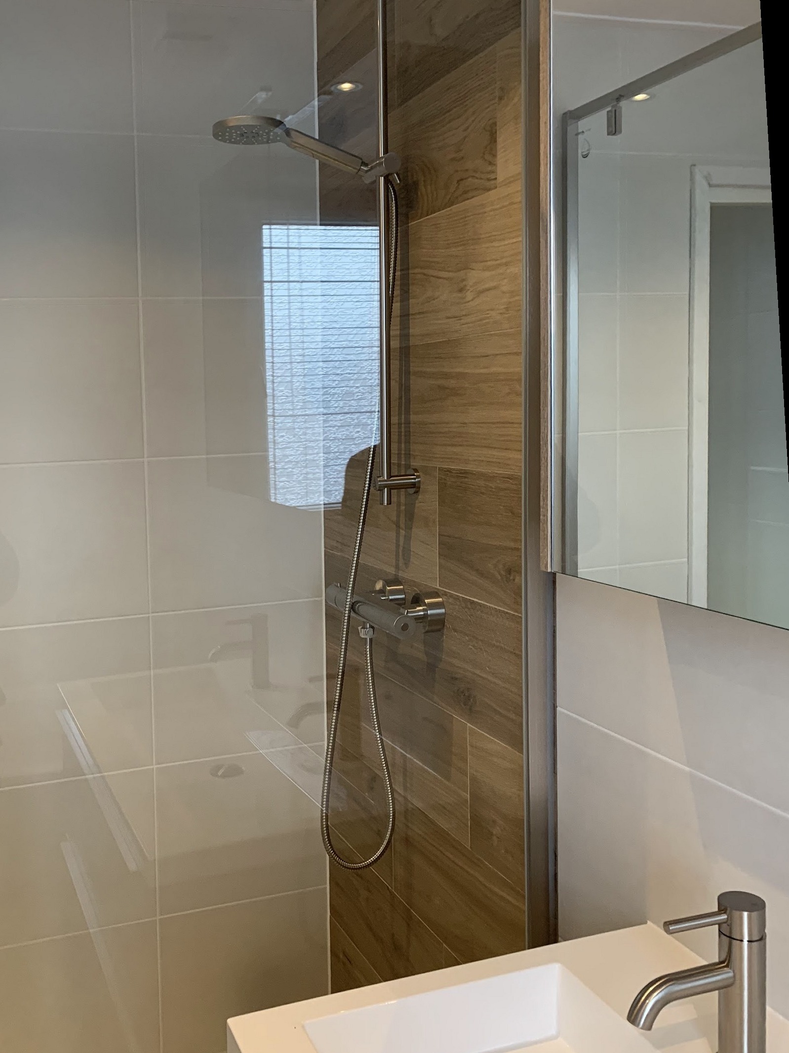 Opgeleverde douche met regendouche, houtlook tegels en wastafel